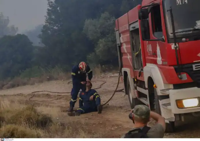 Φωτιά στην Πάρνηθα: Πυροσβέστης φροντίζει συνάδελφο στο πύρινο μέτωπο